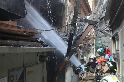 5일 오후 불이 난 서울 종로 3가 쪽방촌에 소방관들이 화재를 진압하고 있다. <연합뉴스>